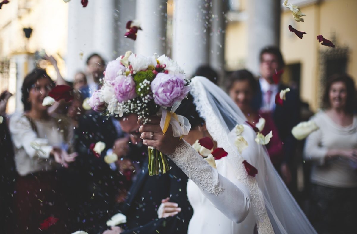 donna in abito da sposa cammina con un bouquet in mano